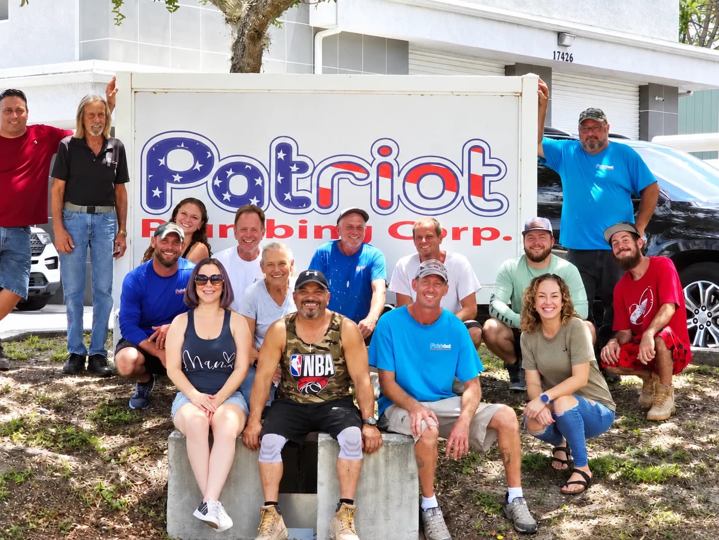 The Patriot Plumbing Corp team in front of the company sign at their Port Charlotte office